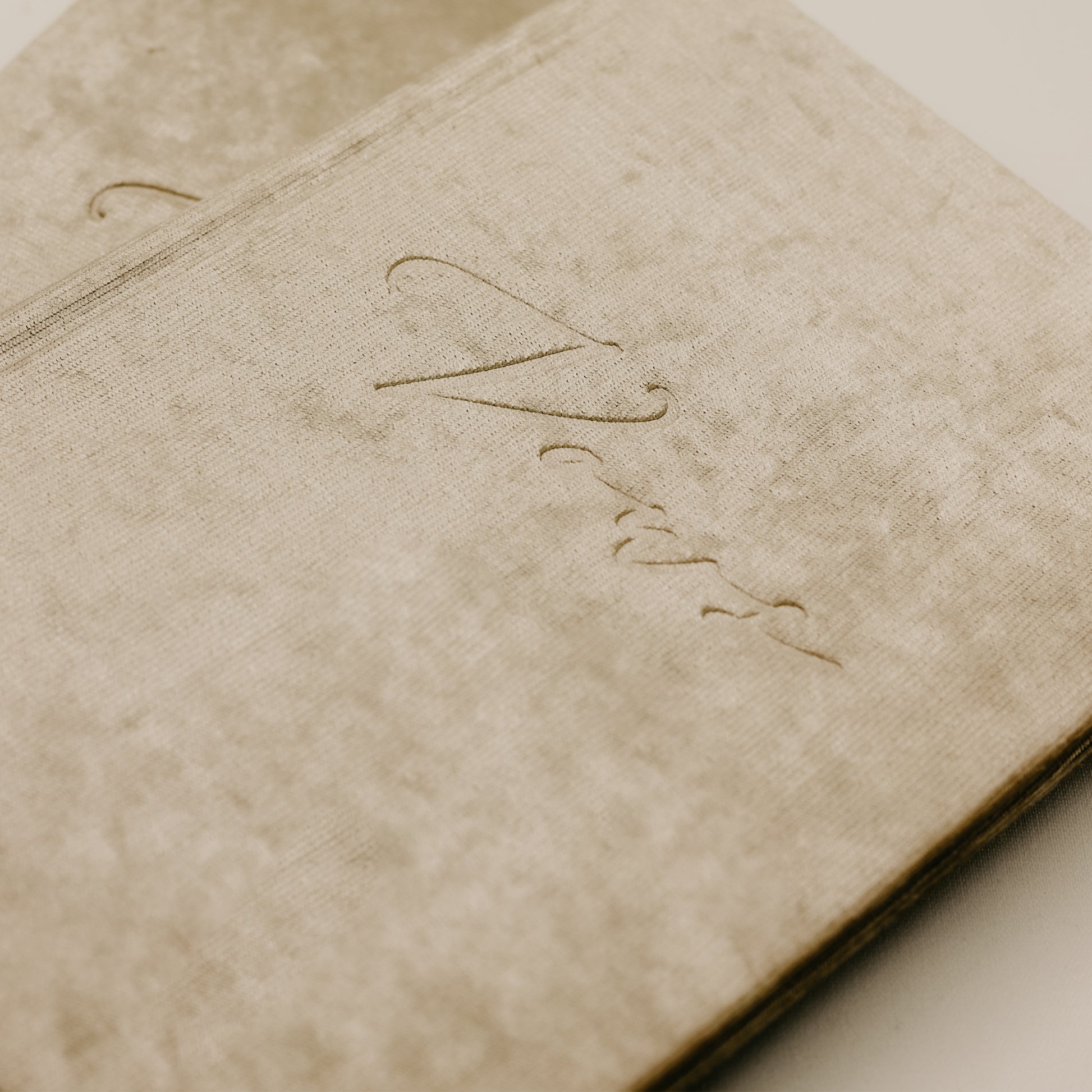 Close-up of a velvet vow book, showing the embossed 'vows' and a ribbon tie on the spine, available in multiple velvet and ribbon colors