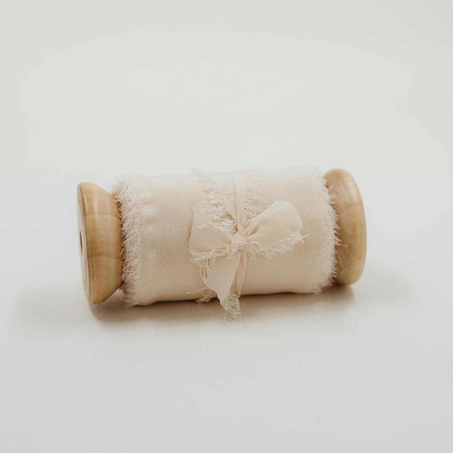 Handmade, raw edge silk ribbon, displayed as a styling element in a bridal flat lay photo