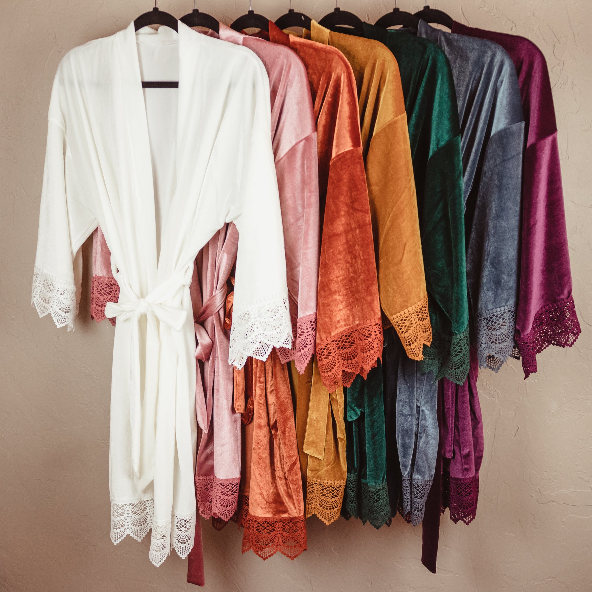 Wrap your bridesmaids in the sumptuous comfort of these velvet robes, featuring intricate lace sleeves for a touch of refined luxury