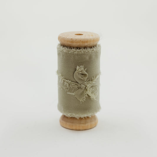 Spool of raw edge silk ribbon in sage color for wedding