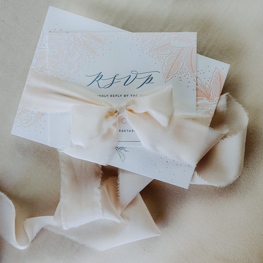 Silk ribbon used for tying wedding invitations in a pretty bow