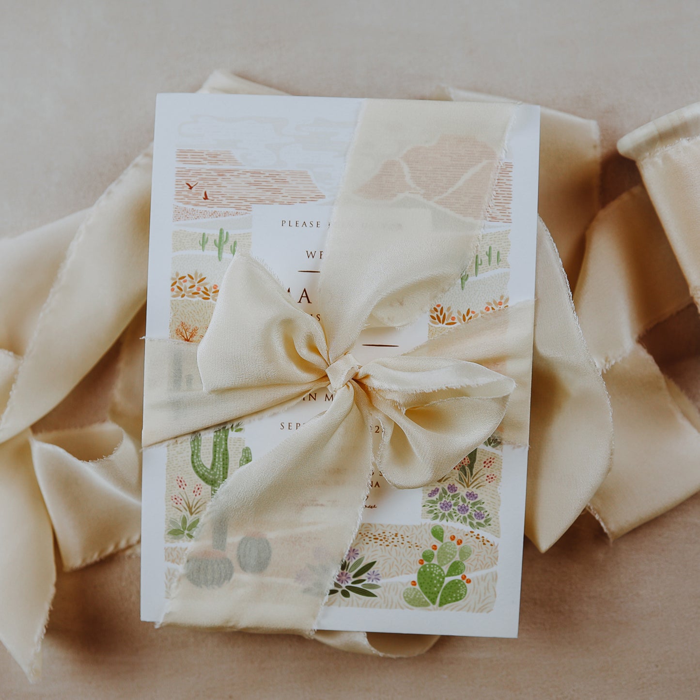 Hand-dyed silk ribbon with a raw edge, used in flat lay photography for wedding invitations and stationery